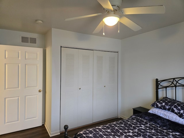 bedroom featuring ceiling fan, dark hardwood / wood-style flooring, and a closet