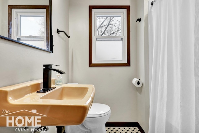 bathroom featuring sink, plenty of natural light, and toilet