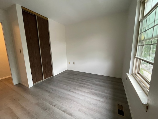 unfurnished bedroom featuring a closet and hardwood / wood-style flooring