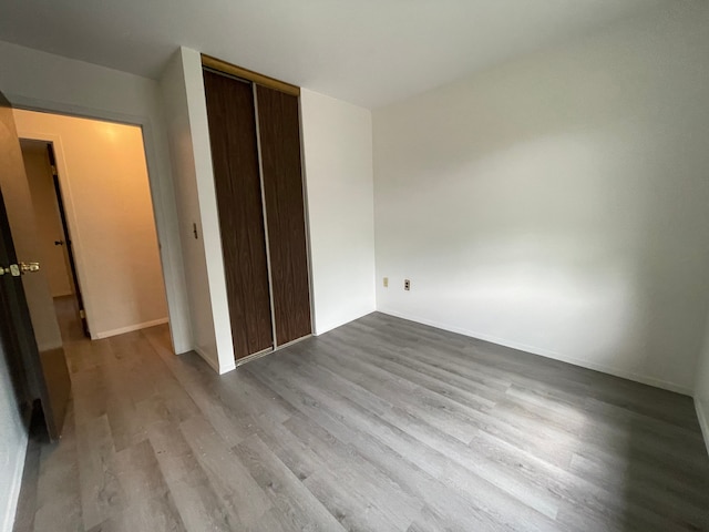 unfurnished bedroom featuring light wood-type flooring and a closet