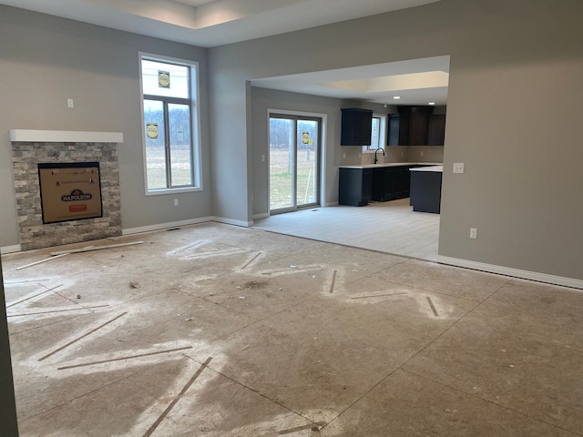 unfurnished living room featuring sink and a wealth of natural light