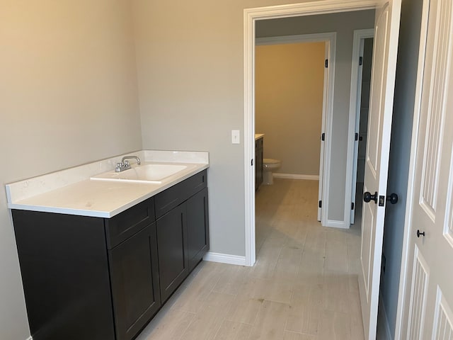 bathroom with hardwood / wood-style flooring, toilet, and vanity