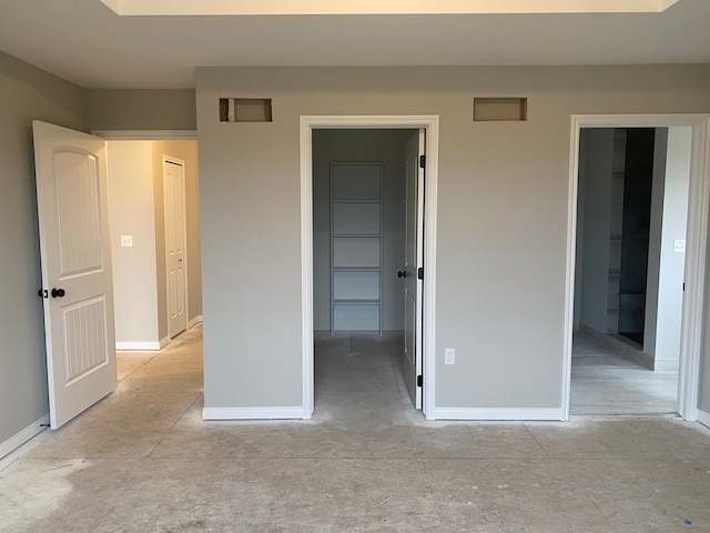 unfurnished bedroom with a walk in closet and a closet