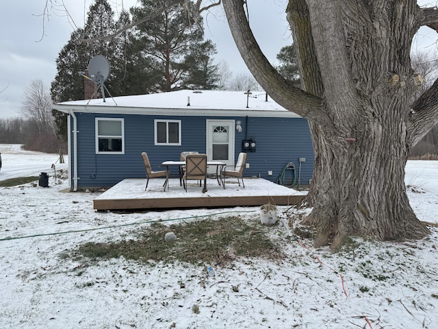 snow covered rear of property featuring a wooden deck