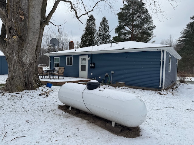 view of snow covered back of property