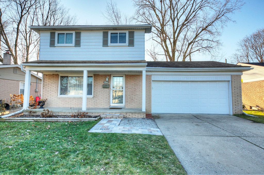 view of front property with a front yard, a garage, and a porch