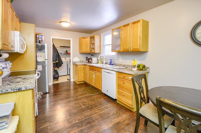 kitchen with washing machine and dryer, sink, light stone counters, and white appliances