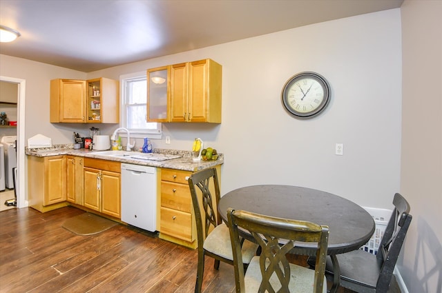 kitchen with sink, dark hardwood / wood-style floors, dishwasher, light stone countertops, and washer and clothes dryer