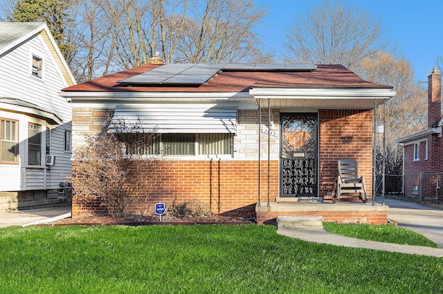 view of front of home featuring solar panels and a front yard