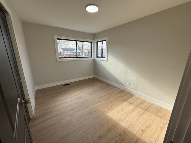 interior space featuring light wood finished floors, baseboards, and visible vents