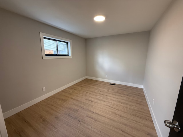 unfurnished room with visible vents, light wood-style flooring, and baseboards