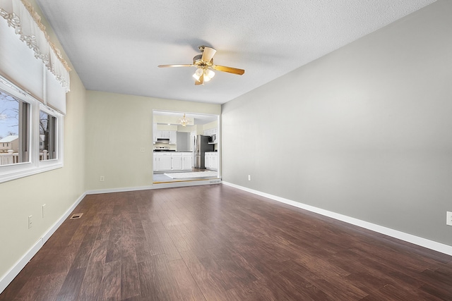 unfurnished living room featuring hardwood / wood-style floors, ceiling fan with notable chandelier, and a textured ceiling