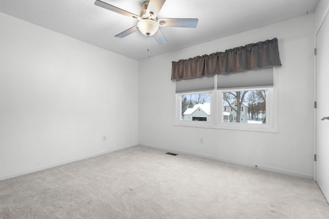 unfurnished room featuring ceiling fan, carpet floors, and a textured ceiling