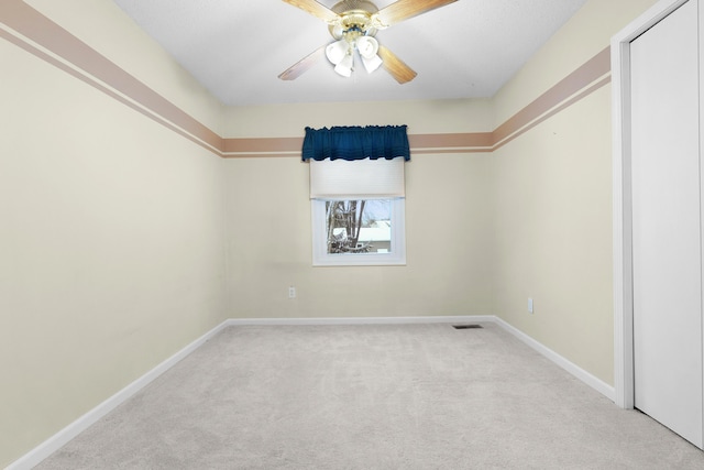 carpeted empty room featuring ceiling fan