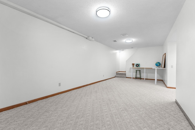 carpeted empty room with a textured ceiling