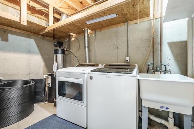 clothes washing area with separate washer and dryer and sink