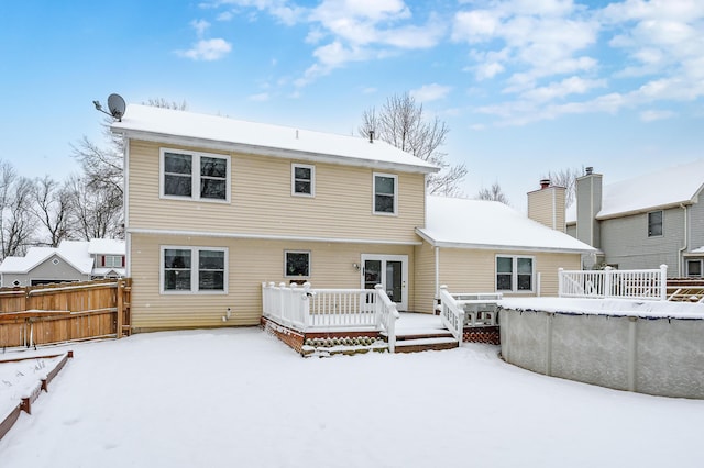 snow covered house featuring a pool side deck