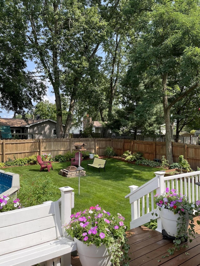 view of yard featuring a deck and a fire pit