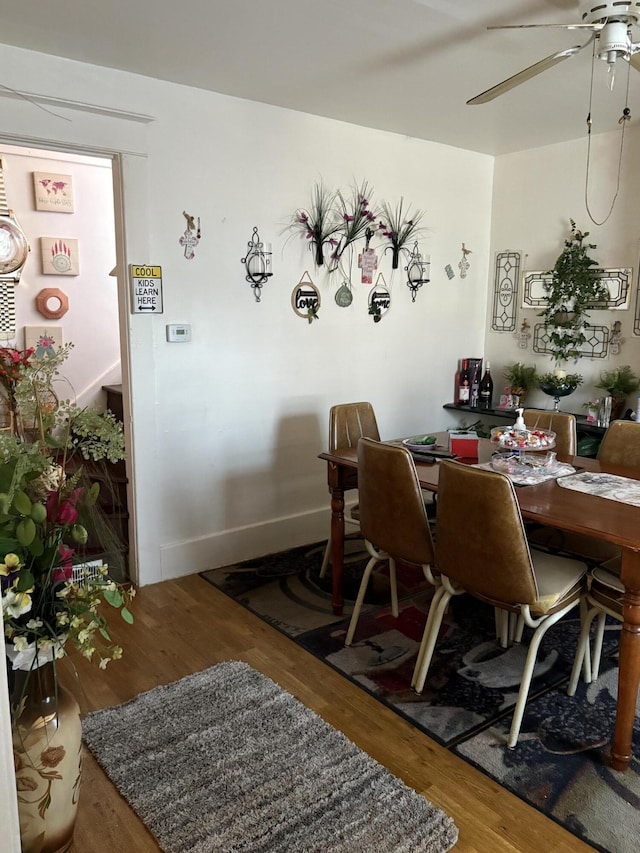 dining space with ceiling fan and wood-type flooring