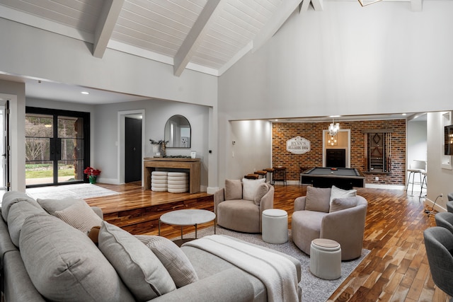 living room with beamed ceiling, brick wall, high vaulted ceiling, and hardwood / wood-style floors