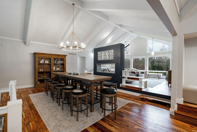 dining room featuring an inviting chandelier, high vaulted ceiling, beam ceiling, and dark wood-type flooring