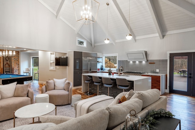 living room featuring billiards, beam ceiling, light hardwood / wood-style floors, and a healthy amount of sunlight