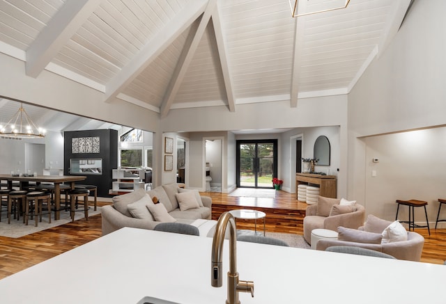 living room featuring beam ceiling, hardwood / wood-style floors, and high vaulted ceiling