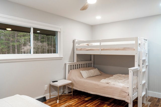 bedroom with dark hardwood / wood-style flooring and ceiling fan