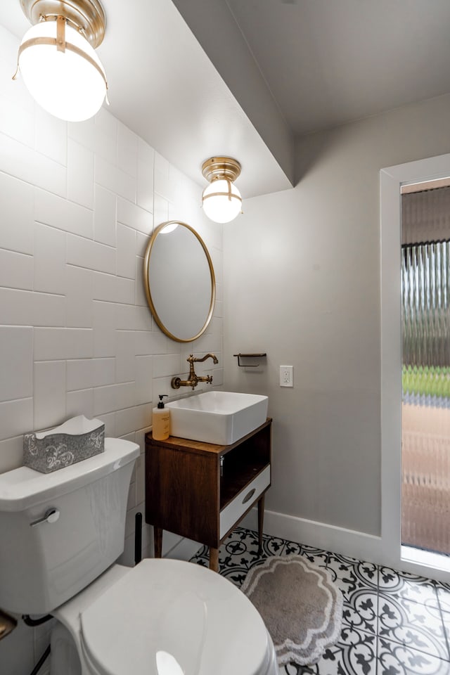 bathroom featuring vanity, tile patterned floors, tile walls, and toilet