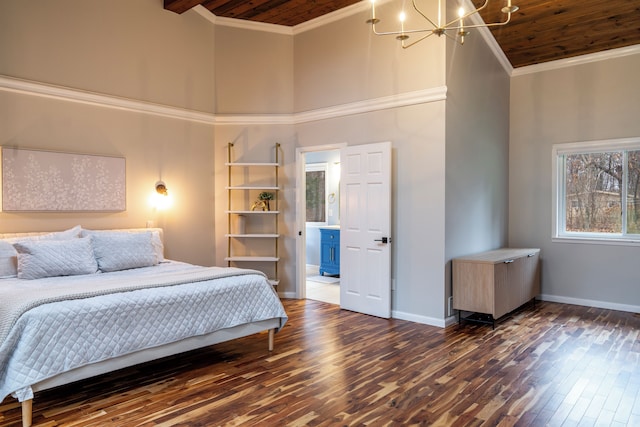 bedroom with a notable chandelier, a towering ceiling, dark wood-type flooring, and ornamental molding