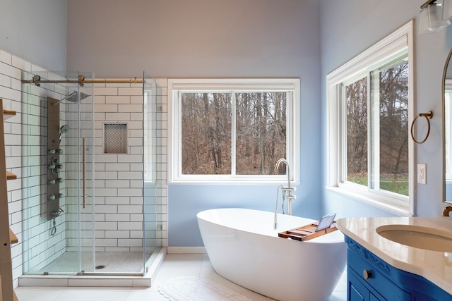 bathroom featuring vanity, plus walk in shower, and a wealth of natural light