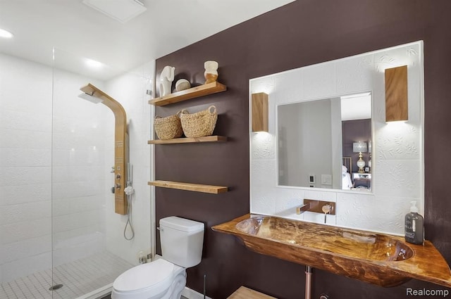 bathroom featuring toilet and a shower with door