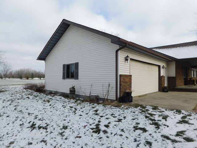 view of snowy exterior featuring a garage