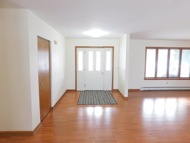 foyer entrance with light wood-type flooring and baseboard heating