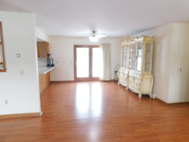 unfurnished living room with french doors, light hardwood / wood-style flooring, and ceiling fan