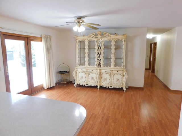 unfurnished bedroom with ceiling fan, access to exterior, and wood-type flooring