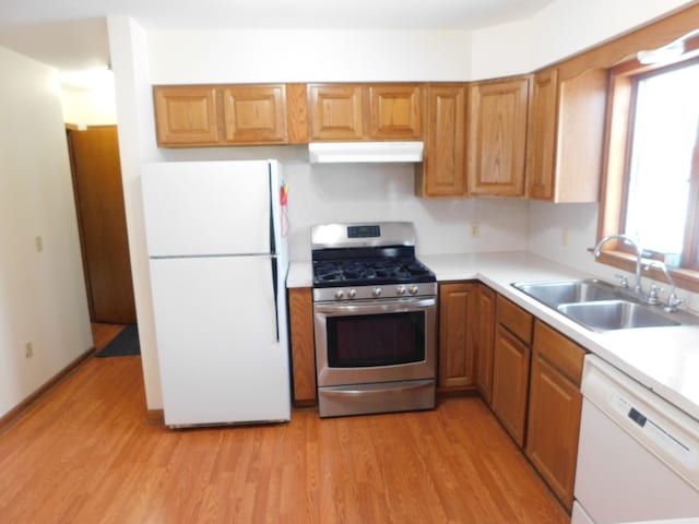 kitchen with white appliances, light hardwood / wood-style flooring, and sink