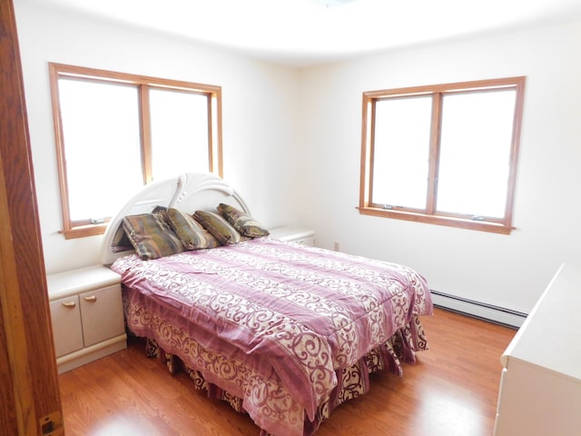 bedroom with light hardwood / wood-style flooring and a baseboard radiator