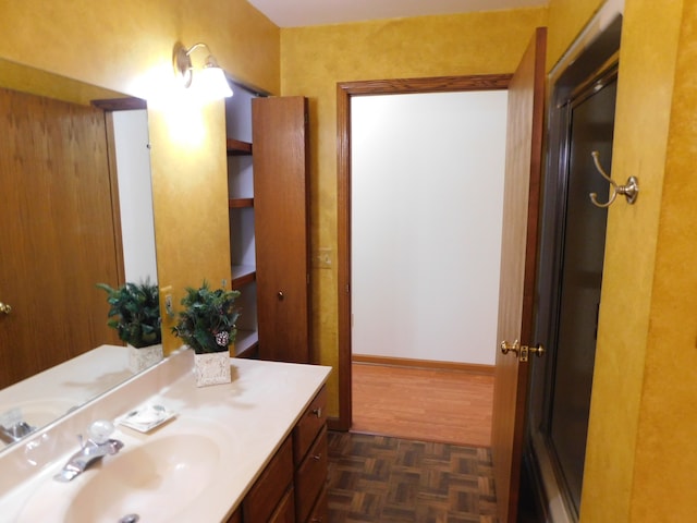 bathroom with vanity, a shower with door, and parquet floors