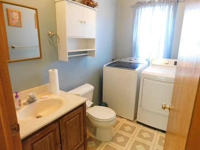 bathroom with independent washer and dryer, vanity, and toilet