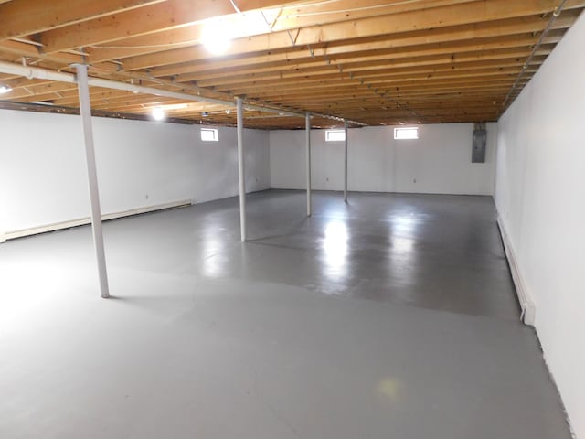 basement with electric panel and a baseboard radiator