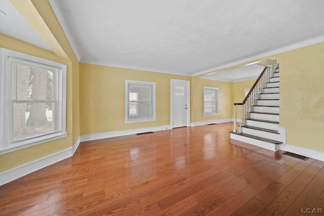 unfurnished living room featuring a healthy amount of sunlight and hardwood / wood-style flooring