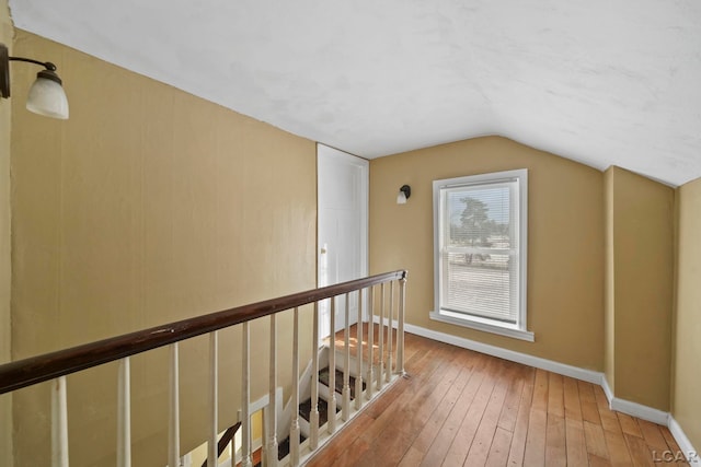 additional living space featuring vaulted ceiling and hardwood / wood-style flooring