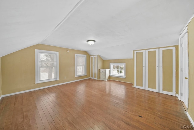 bonus room with light hardwood / wood-style flooring and vaulted ceiling