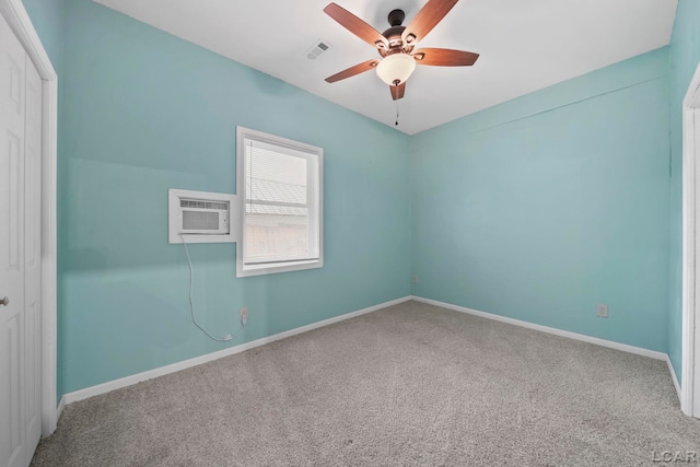 spare room featuring ceiling fan, carpet, and a wall mounted air conditioner