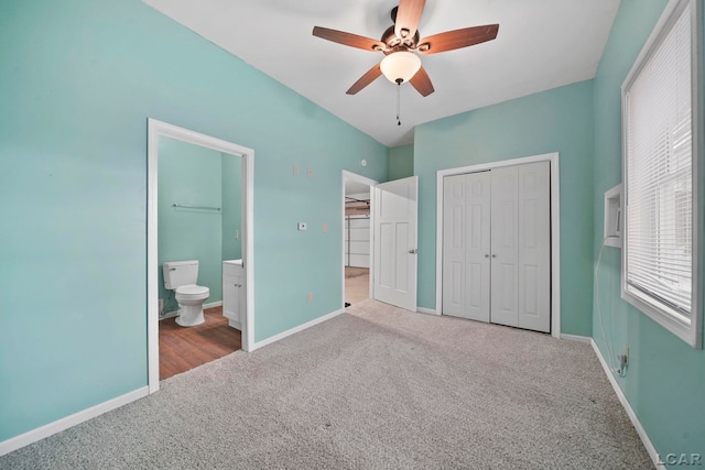 unfurnished bedroom with light carpet, a closet, ceiling fan, and ensuite bathroom