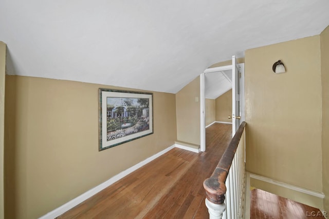 hall with wood-type flooring and lofted ceiling