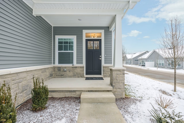 snow covered property entrance featuring covered porch