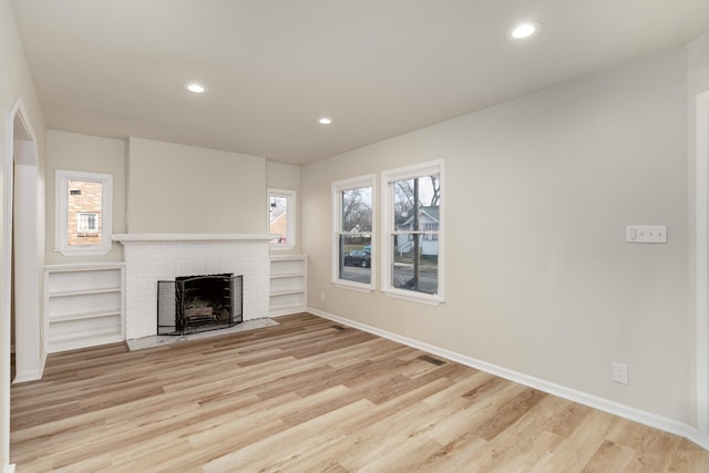 unfurnished living room with a fireplace and light hardwood / wood-style flooring