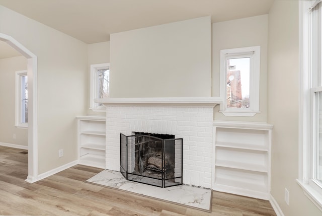 details with hardwood / wood-style floors and a brick fireplace